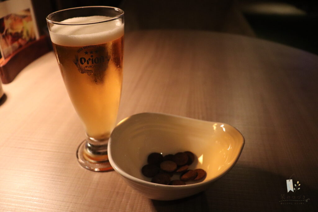 オリオンビールのグラスと、小鉢に入ったおつまみ